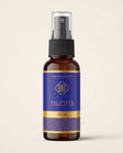 Nubra parfum 50 ml, etichetă albastră, flacon chihlimbariu pe fundal crem