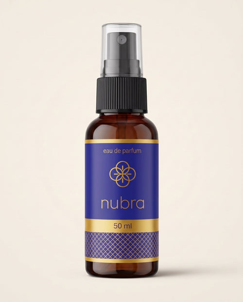 Nubra parfum 50 ml, etichetă albastră, flacon chihlimbariu pe fundal crem